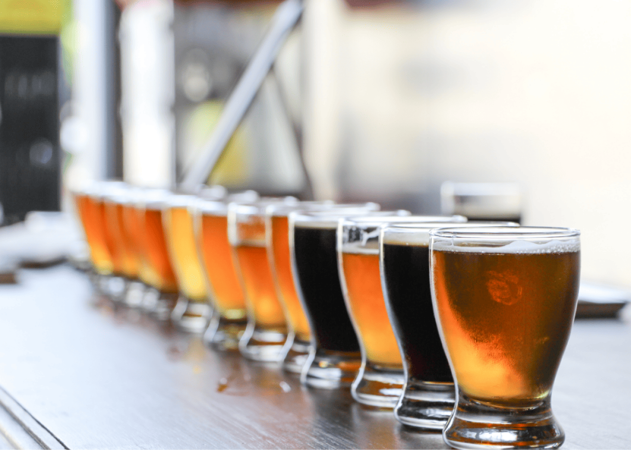 A selection of craft beers are lined up on a counter.